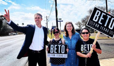 Beto O'Rourke gestures to passing cars as he gets out the vote with his wife Amy and two supporters in Mission, Texas