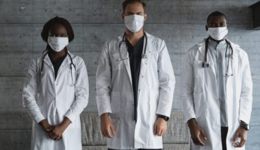doctors in white coat wearing face masks